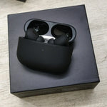 Black wireless earbuds in a charging case on a black box.
