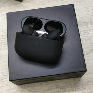 Black wireless earbuds in a charging case on a black box.