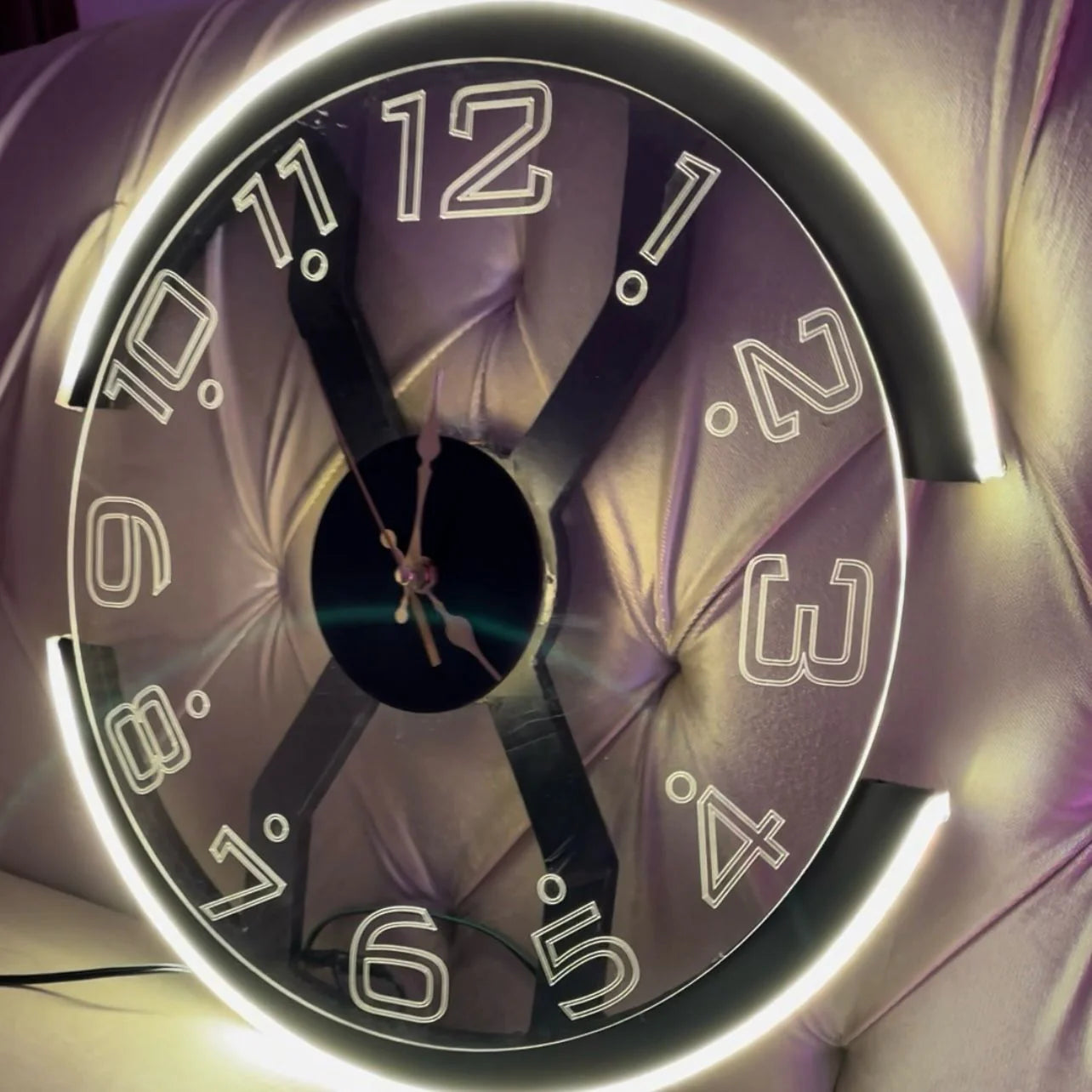 Close-up of a clock face with glowing numbers and hands on a reflective surface.