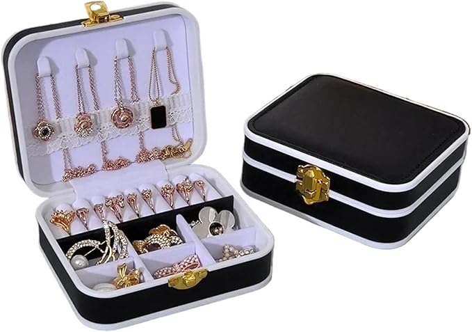 Black and white jewelry box with open lid displaying various necklaces and bracelets.