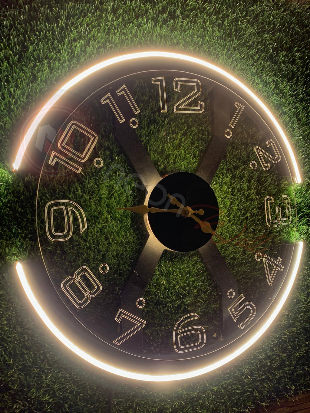 Circular clock face with numbers on a grassy background