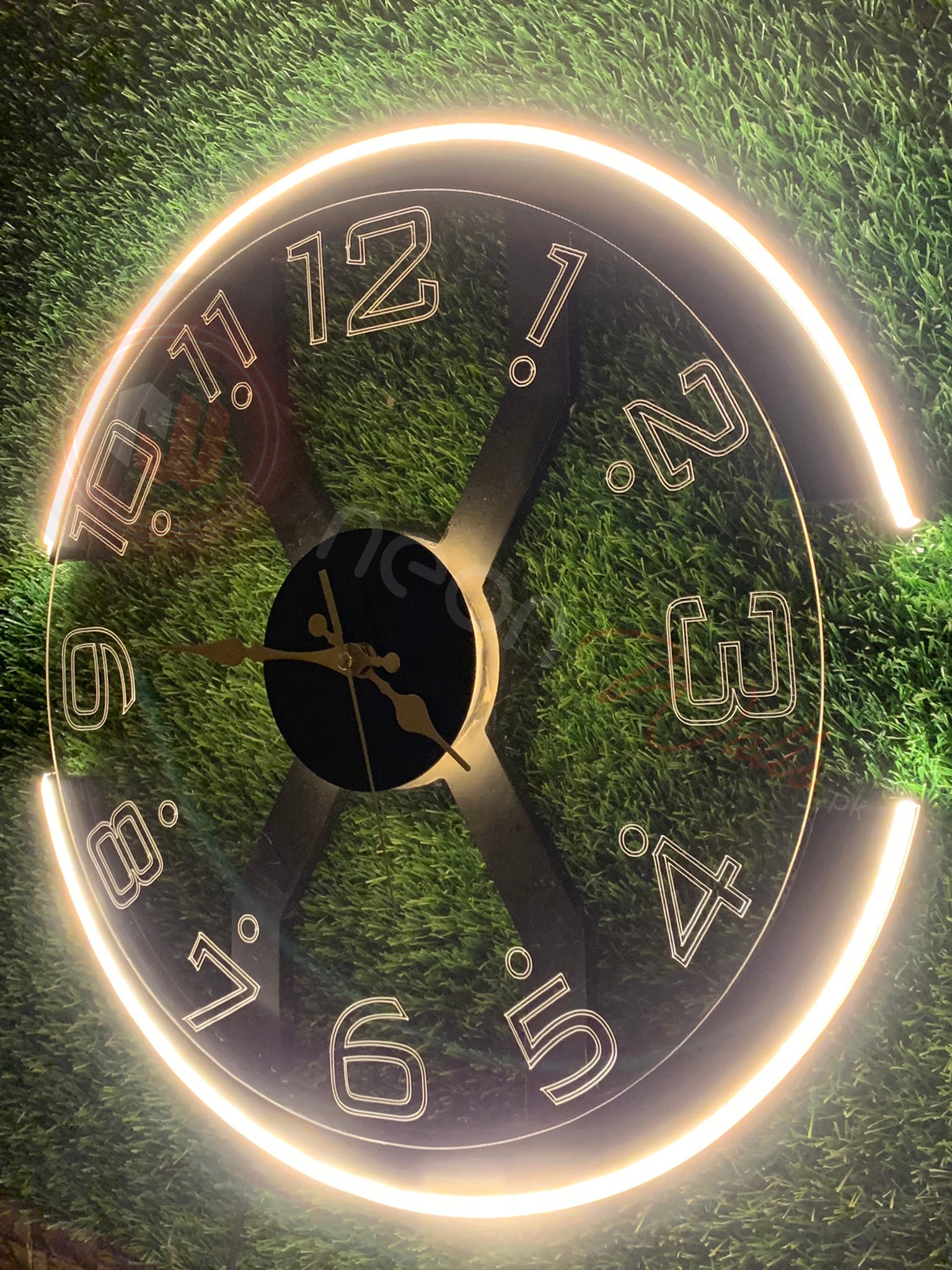 Decorative clock with glowing edge on a green grass background