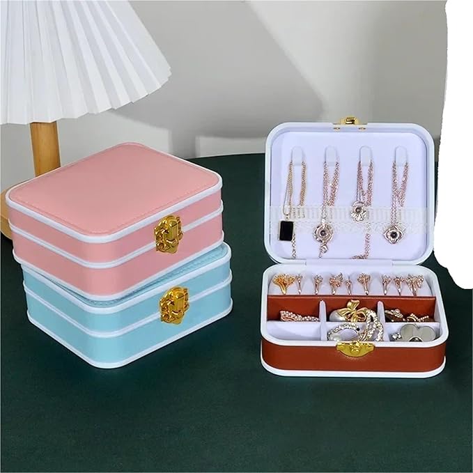 Set of jewelry boxes in pink, blue, and brown with jewelry inside on a dark surface.