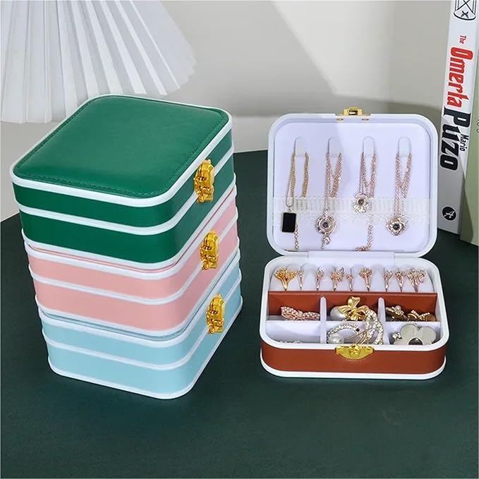 Stack of colorful jewelry boxes with an open one displaying necklaces on a dark surface.