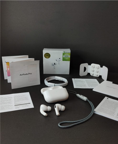 Apple AirPods Pro with accessories and documentation on a dark surface